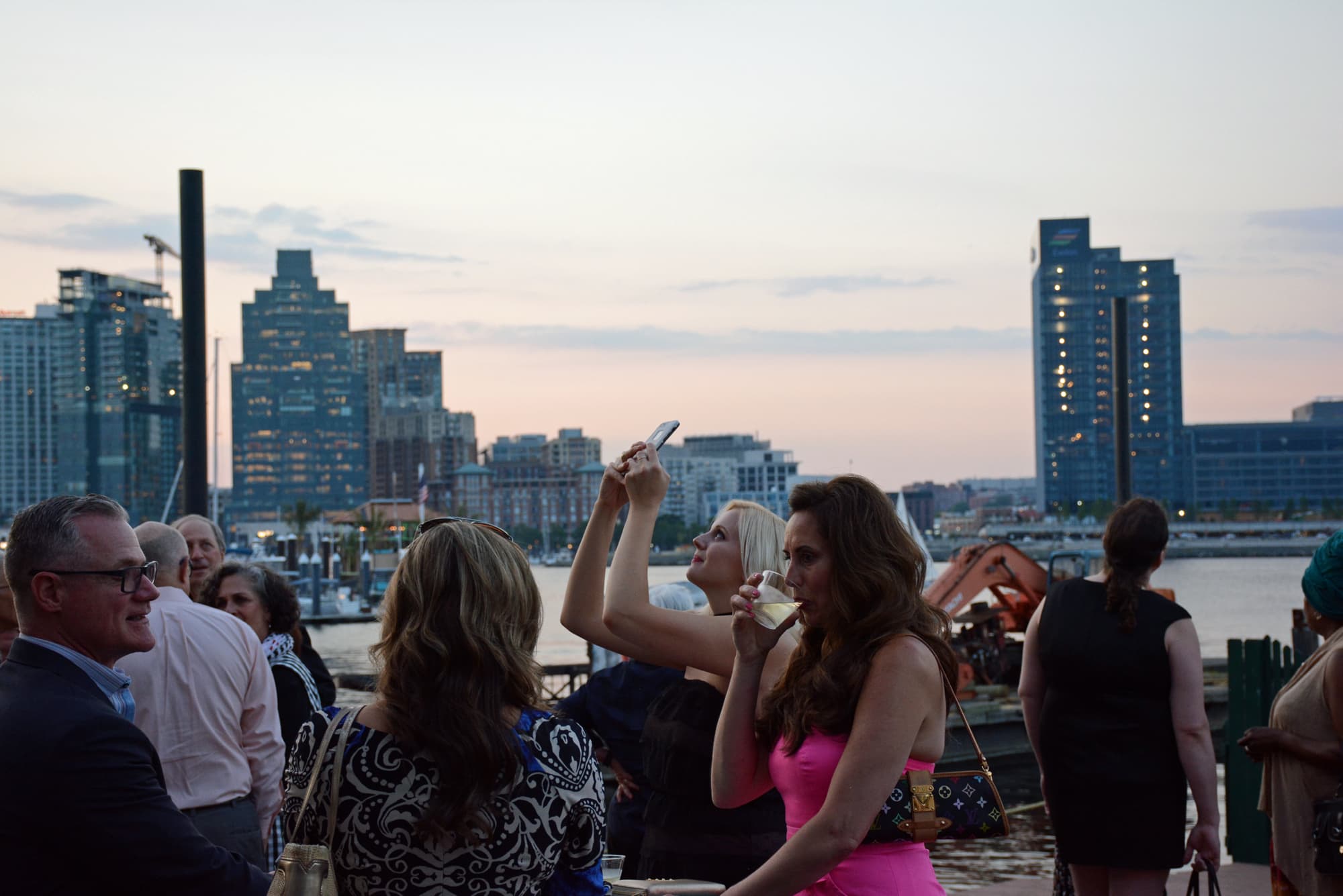 Guests mingled inside and outside the Baltimore Museum of Industry, enjoying the Inner Harbor at dusk.
