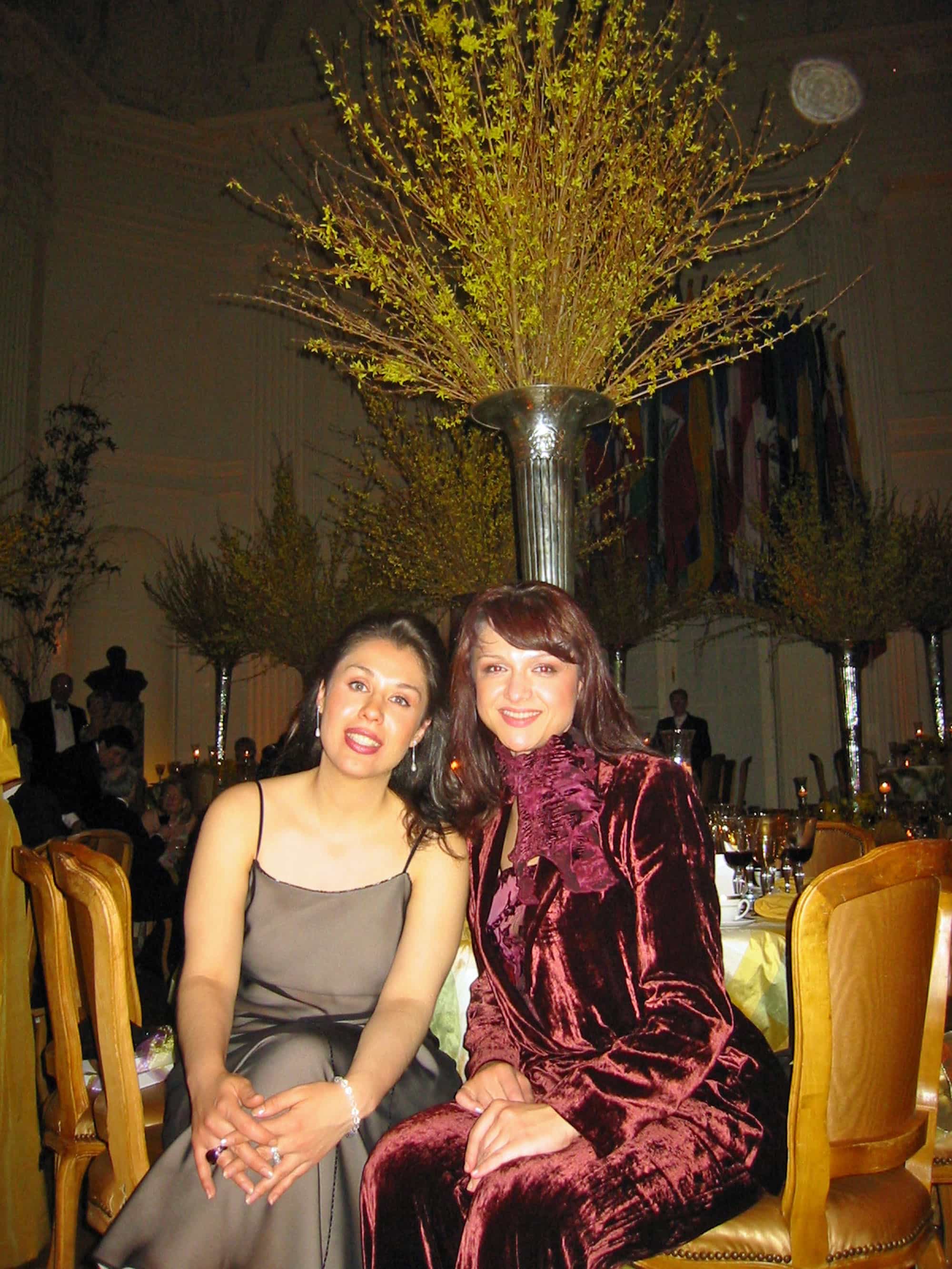 Operatic sopranos Eugenia Garza and Tatiana Pavlovskaya also took a pared-down approach at their formal dinner. Garza is wearing a simple bronze sheath with spaghetti straps by Adrianna Pappell, while Pavlovskaya is channeling her inner ‘70s with a velvet burgundy pantsuit by – “I can’t remember!” she said. But, it looks very vintage Yves St. Laurent to me.